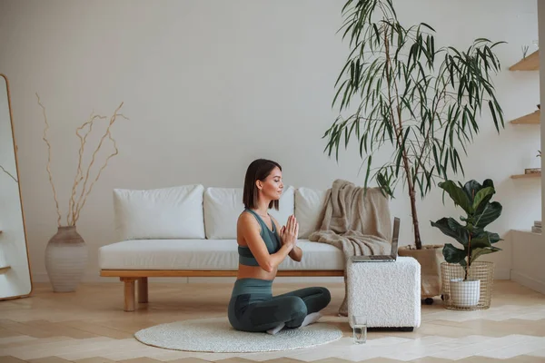 Eşofmanlı Esmer Bir Kadın Evdeki Bir Dizüstü Bilgisayarda Yoga Yapıyor — Stok fotoğraf