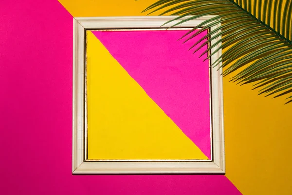 white retro frame with yellow-pink background around the frame pink-yellow background with palm leaf, creative retro modern summer design, copy space