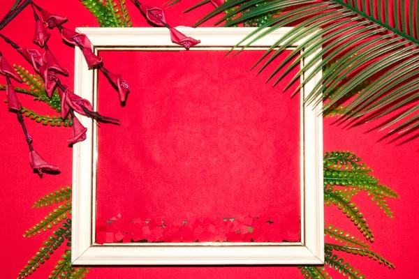 old retro frame with red copy space, around it a row of wallpaper with jungle leaves and flowers, modern summer party romance wallpaper