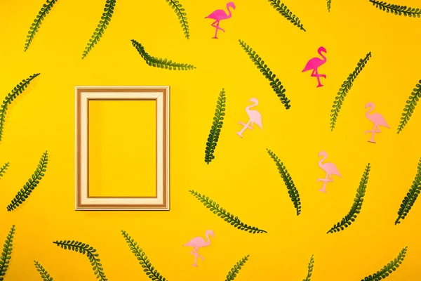 yellow background with wooden frame as copy space on the left side of the background, colorful flamingos and leaves on a yellow background, creative summer modern design
