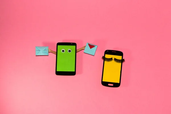mobile phone with green screen as copy space holds two messages in hand while another phone with yellow copy space sleeps from boredom, creative art design on pink background