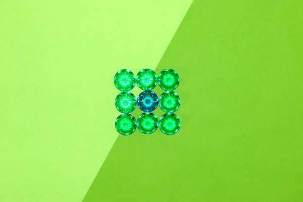 square of fake gemstone green color and one blue, green background in two shades, creative modern art design