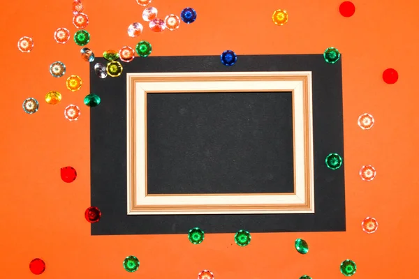 wooden frame on black orange background, frame as copy space, around colorful fake gemstone, creative modern design, trendy colors