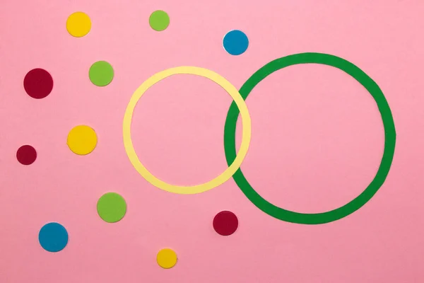 green and yellow circle as copy space on pink background around colorful dots, dot day