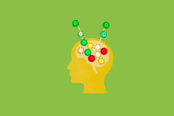 yellow paper head with brain sharing information with outside world, creative art idea on green background