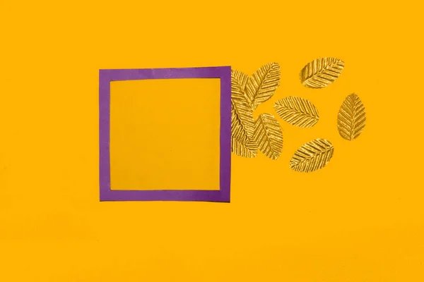 purple frame as copy space on a yellow background, golden leaves fly from the frame, creative art luxury design