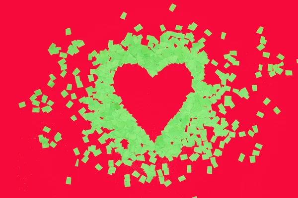 green heart on row background, scattered green leaves around, minimal love design