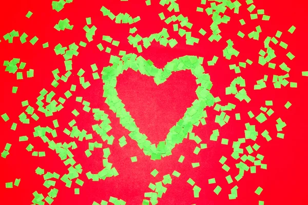 green heart on a row background, scattered green leaves around, creative art love design, copy space