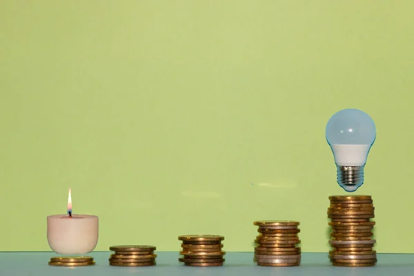 diagram of coins, energy crisis, light bulb at the top of the diagram, candle at the bottom of the diagram, increase in the price of electricity energy