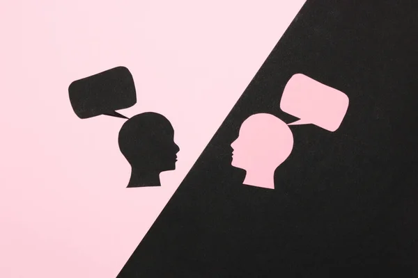black and pink background, with a black part pink head with a speech bubble, on the pink part a black head with a speech bubble, communication creative art design