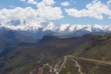 Ermeni köyü Halidzor 'un karlı dağ tepelerinin manzarası teleferiğin yanında 