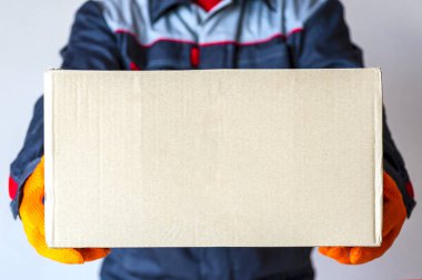 Teslimatçı adam paketi. Kurye kutusu. Fotokopi alanı olan karton taşıyan bir adam. yakın plan