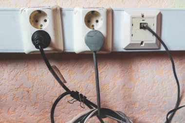 Ofiste prizler ve kablolar var. Duvarda bir çift priz var.