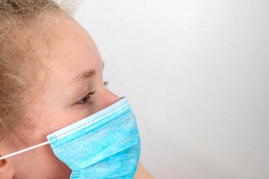 Koruyucu maskeli kız. Tıbbi maske yakın plan. Bulaşıcı hastalıkları koruma konsepti. Coronovirus, COVID-19, Karantina konsepti.