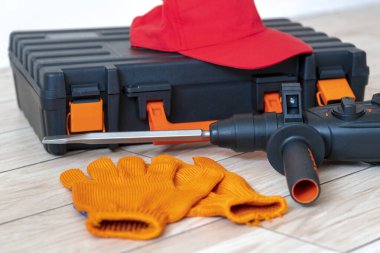 Çalışan aletlerin üst görüntüsü. Döner çekiç, alet çantası, iş kepi, eldivenler. İşçi vitesi konsepti