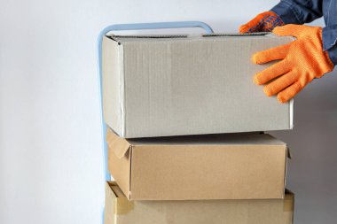 Kurye kutusu. Karton kutular taşıyan bir adam. Teslimat konsepti ve eşya boşaltma, karton kutular. yakın plan