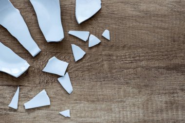 Arka planda parçalar var. Kıymıklar, yerdeki bir sofra takımının parçaları. Kırık bir tabağın enkazı ve parçaları, tabak. yakın plan