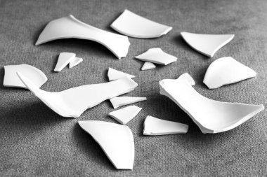 Kırık beyaz kapların kıymıkları ve parçaları. Kırık tabak, cam. Parçalanmış tabak parçaları. Yakın plan, kenar görünüm