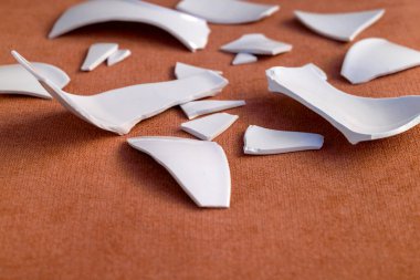 Kırık beyaz kapların kıymıkları ve parçaları. Kırık tabak, cam. Parçalanmış tabak parçaları. Yakın plan, kenar görünüm