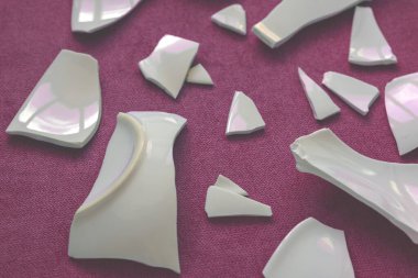 Kırık beyaz kapların kıymıkları ve parçaları. Kırık tabak, cam. Parçalanmış tabak parçaları. Yakın çekim, üst görünüm