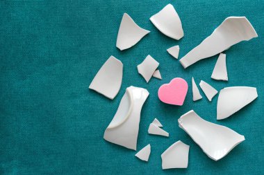 Parçaların arasında bir kalp. Mutsuz aşkın sembolü. Kötü sağlık konsepti. Beyaz parçalar ve kalp. Üst Manzara. Boşluğu kopyala