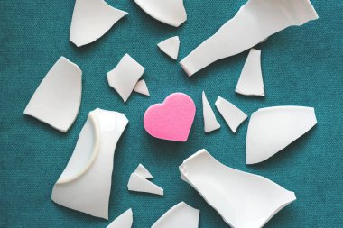 Parçaların arasında bir kalp. Mutsuz aşkın sembolü. Kötü sağlık konsepti. Beyaz parçalar ve kalp. en üstteki görünüm