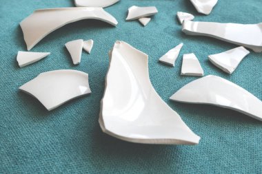 Kırık beyaz kapların kıymıkları ve parçaları. Kırık tabak, cam. Parçalanmış tabak parçaları. Yakın plan, kenar görünüm