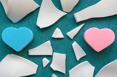 Parçaların arasında kalpler. Mutsuz aşkın sembolü. Beyaz parçalar ve iki kalp.