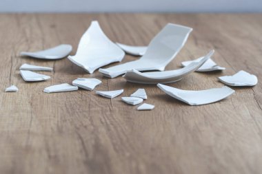 Kırık beyaz kapların kıymıkları ve parçaları. Kırık tabak, cam. Parçalanmış tabak parçaları. Yakın plan, kenar görünüm