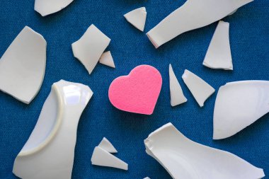 Parçaların arasında bir kalp. Mutsuz aşkın sembolü. Kötü sağlık konsepti. Beyaz parçalar ve kalp. en üstteki görünüm