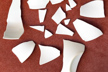 Kırık beyaz kapların kıymıkları ve parçaları. Bir aile kavgasının metaforu. Kırık tabak, cam. Mutfaktaki kaza kavramı. Parçalanmış tabak parçaları. en üstteki görünüm