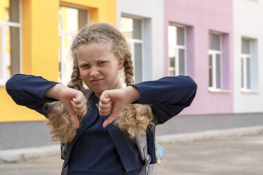 Okulun arka planında bir kız öğrencinin portresi. Konsept okul günleri, okula dönüş. Sırt çantalı üniformalı bir kız. Öğrenci, öğrenci, alim..