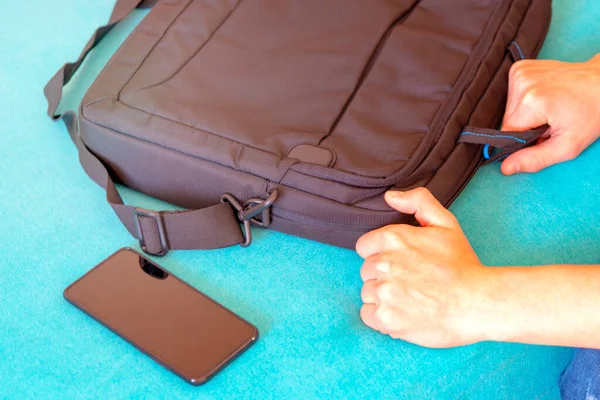 Akıllı telefon ve laptop çantası. El dizüstü bilgisayar çantasını alır.