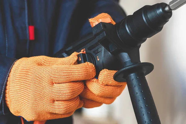  İşçi döner çekiçle yön değiştiriyor. El değiştirme modunda çekiç delme delgisi var. yakın plan