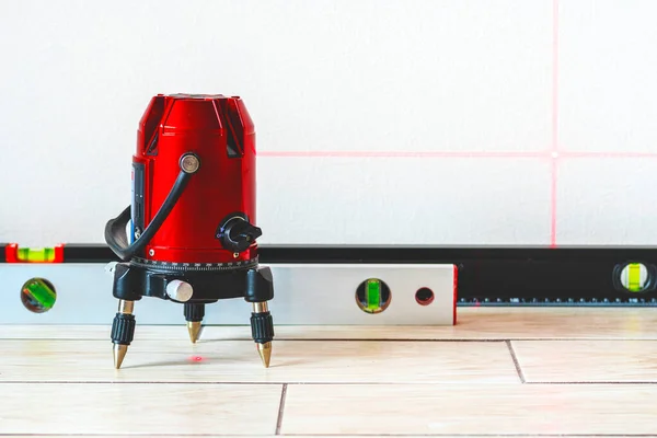 Laser level and Bubble levels, lines on the wall. measuring  with red laser level.Measurement accuracy concept, modern measurement devices