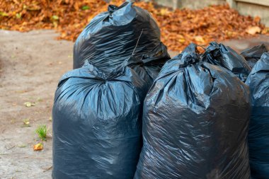Çöp dolu plastik torbalar. Çöplük. Bir yığın israf. Çevresel kirliliği, ekolojik kirliliği hesaba katın. Eski araba lastikleri.