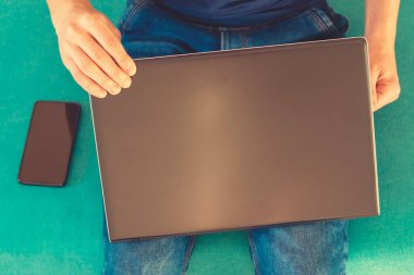 Yakın plan. Bilgisayarlı adam. Bilgisayarlı adam, akıllı telefon. en üstteki görünüm