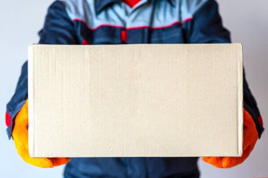 Teslimatçı adam paketi. Kurye kutusu. Fotokopi alanı olan karton taşıyan bir adam. yakın plan