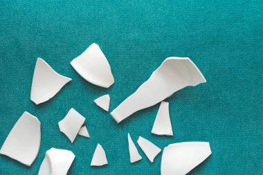 Kırık beyaz kapların kıymıkları ve parçaları. Bir aile kavgasının metaforu. Kırık tabak, cam. Mutfaktaki kaza kavramı. Parçalanmış tabak parçaları.. 