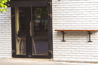 Beyaz tuğlalı arka planda koyu renkli kapılar. Kafeye, dükkana, butiğe, dükkana, restorana Seramik tuğla arka planına giriş. 