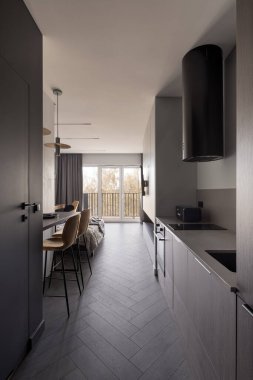 Modern, küçük ve işlevsel mutfak, şık stüdyo dairesinin koridorunda.