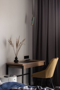 Güzel ve şık bir ofis alanı, küçük, ahşap masa, zarif sarı sandalye ve dekorasyonlar.