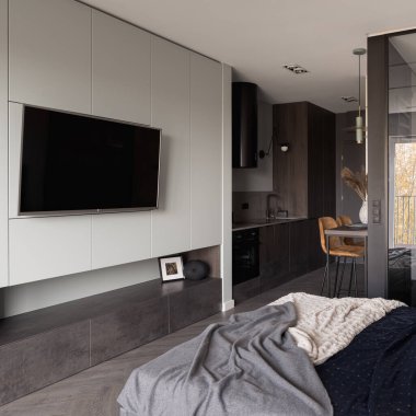 Büyük televizyon şık ve küçük stüdyo dairede. Yatak odası mutfağa açık.