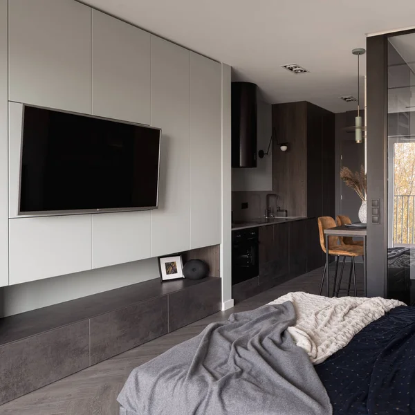Büyük televizyon şık ve küçük stüdyo dairede. Yatak odası mutfağa açık.