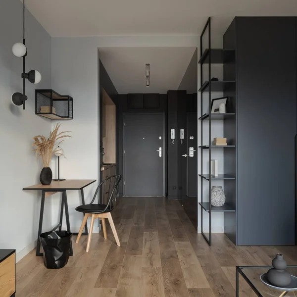 装飾的な照明 木製の床と仕事と勉強のためのスタイリッシュなデスク付きの小規模および近代的なスタジオのアパートのインテリア — ストック写真