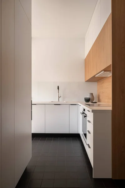 带有深色瓷砖地板 白色橱柜 抽屉和木料装饰的简约现代厨房内部 — 图库照片