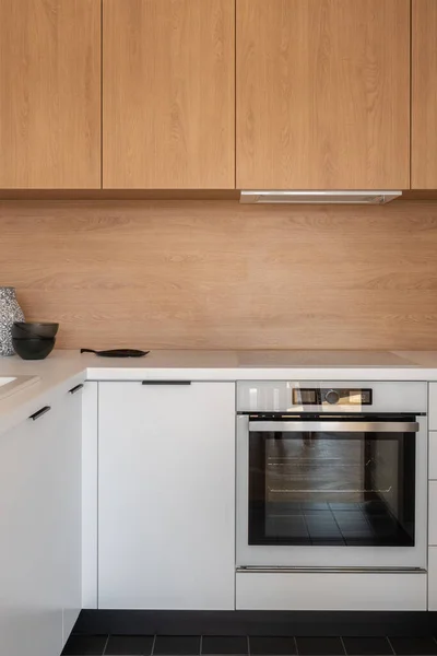 小巧实用的厨房 有白色台面 木制后飞溅瓷砖 木制顶柜和新烤箱 — 图库照片