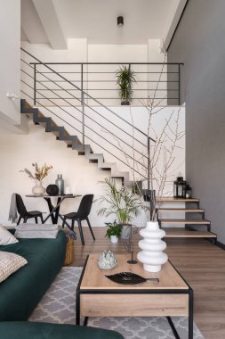 Modern mobilyaları, yemek alanı ve merdivenleri olan iki katlı geniş oturma odası var.