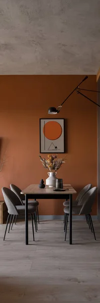 Vertical panorama of modern dining room with table, chairs, art, orange wall, wooden floor and concrete ceiling