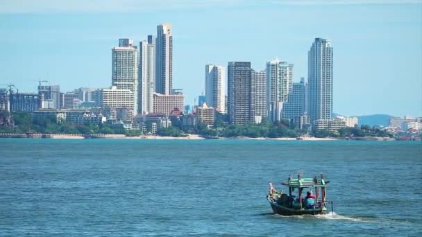 Denizde balıkçı teknesi gezintisi ve Pattaya şehrinin arka planında apartman inşaatı oteli — Stok video